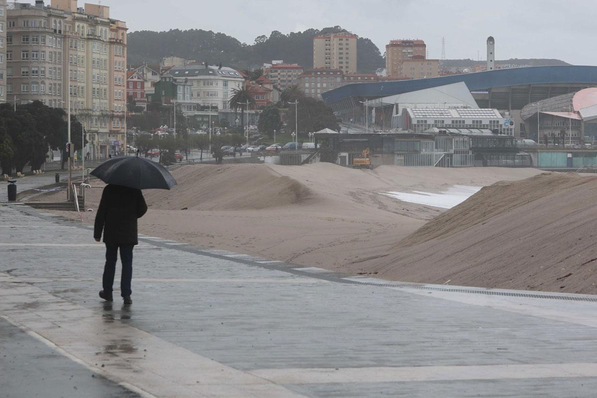 Máquinas trabajando en la duna de Riazor tras el paso de un temporal.
