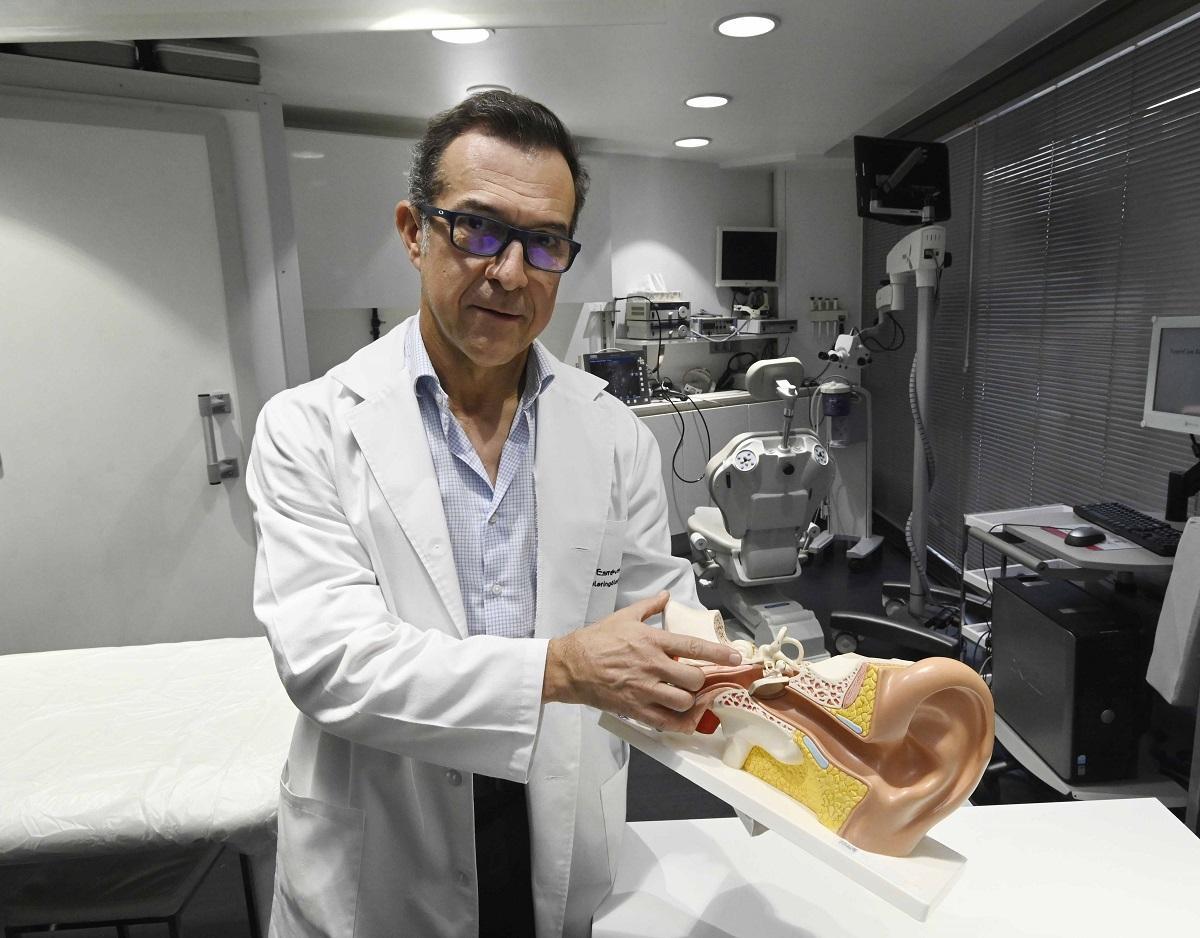 El otorrinolaringólogo Manuel Estévez muestra un implante coclear en un modelo anatómico del oído..