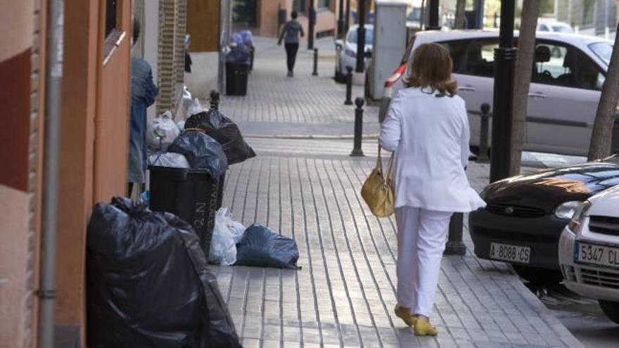 La basura se acumuló el lunes en los portales y las aceras del núcleo urbano de Ontinyent.