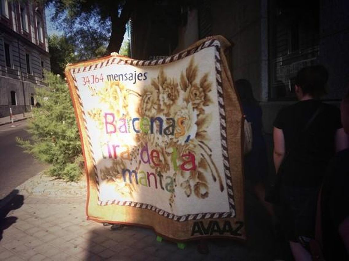 Un grup de ciutadans espera l’arribada de l’extresorer del PP amb una bandera en què es llegeix ’Bárcenas estira la manta’.