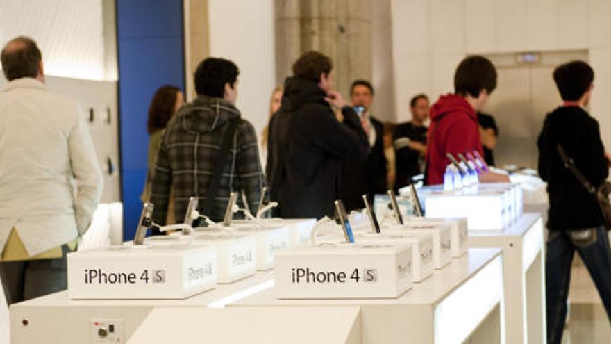 Numerosas personas esperan en una tienda de Madrid para conseguir el nuevo iPhone 4S.