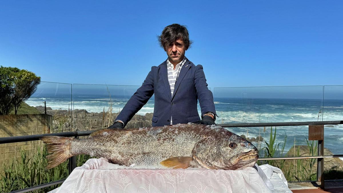 El gerente de Porto dos Barcos, Juan Enrique Carneiro, junto a la corvina salvaje de aproximadamente 30 kilos recibida en el restaurante.