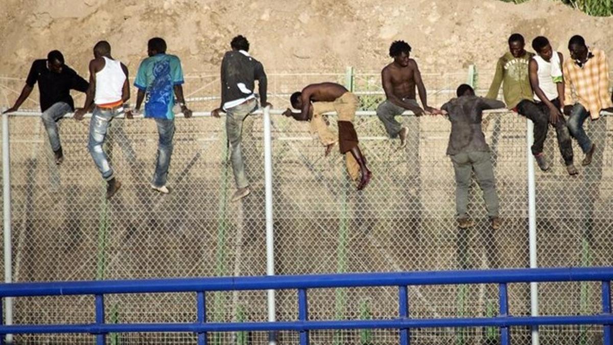 Un grupo de subsaharianos permance en lo alto de la valla de Melilla des de las siete y media de esta mañana.