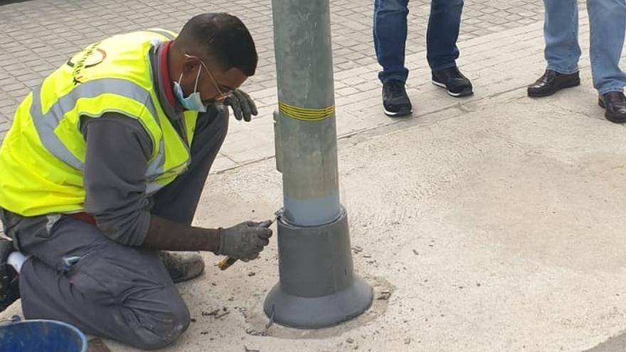 Un operario instala el collarín en una farola