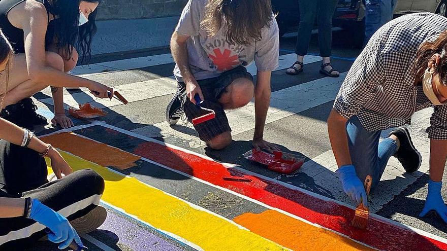 Tècnics i polítics pintant de nou la bandera LGTBI davant del Consell