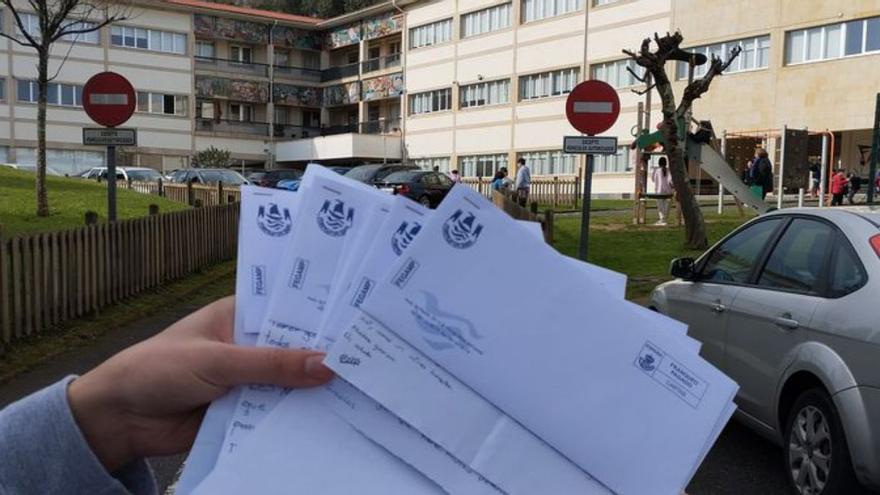Cartas del Concello y, al fondo, el centro educativo. | LOC