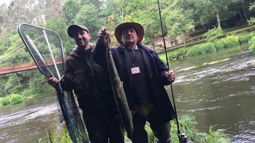 Manolo Aldariz (a la derecha), con el salmón que acaba de extraer del Ulla en Ximonde asistido por un pescador asturiano. // Bernabé / Cris M.V.