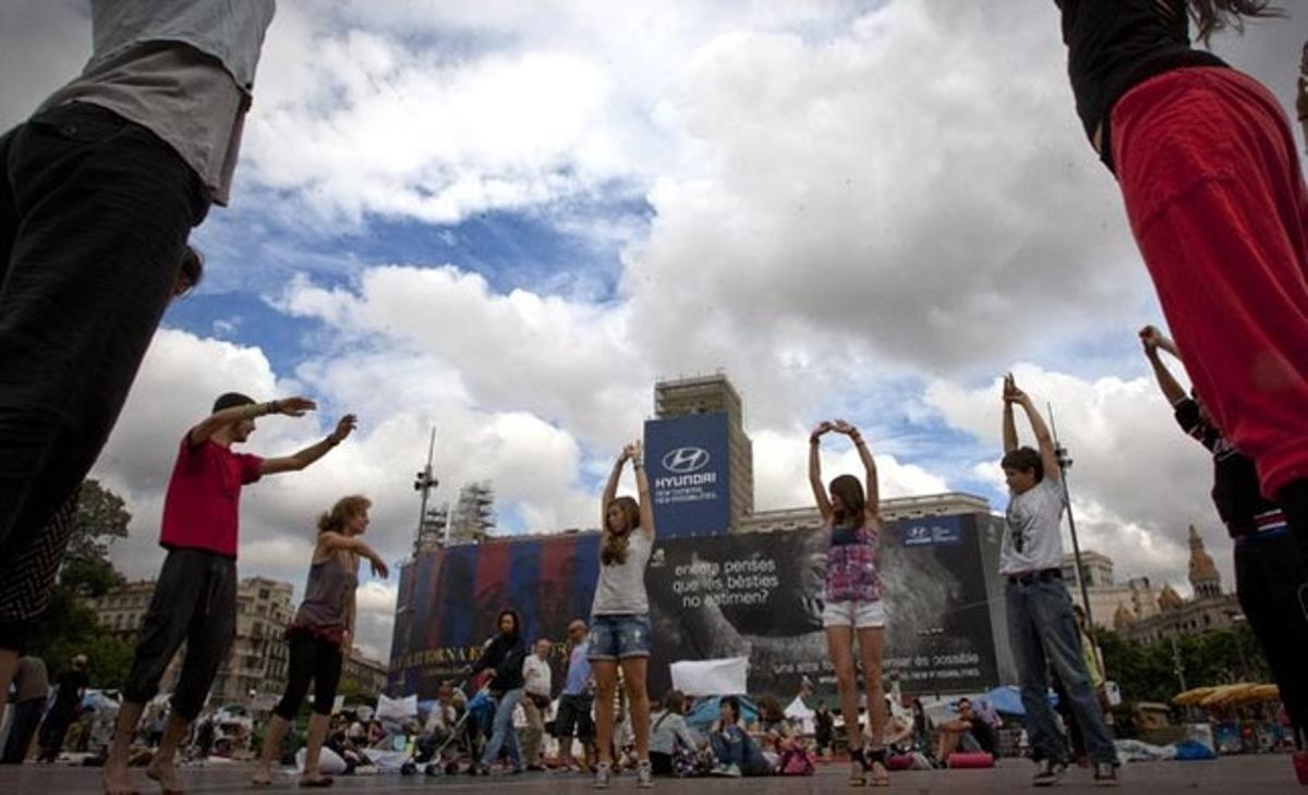 Un grup d’indignats dansen a la plaça de Catalunya, en la tercera setmana d’acampada.