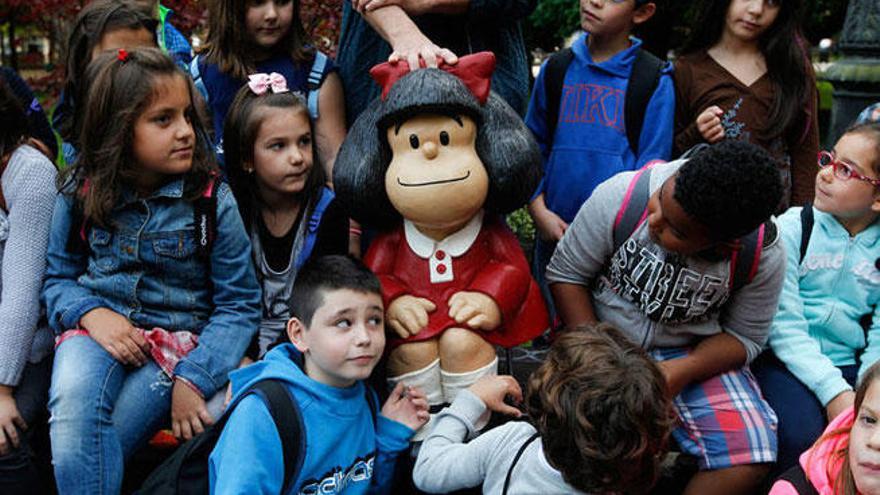 Un grupo de niños alrededor de una escultura de Mafalda en Oviedo.