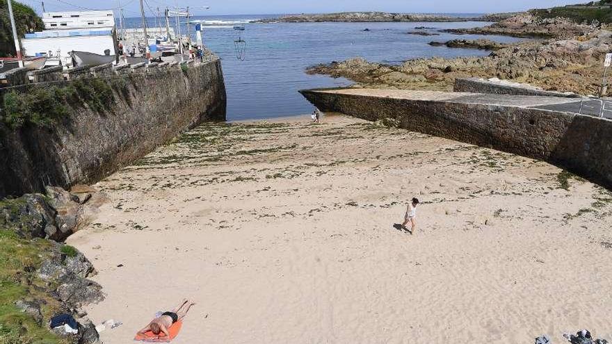 Usuarios en la playa, ayer, en la cala de O Portiño, en la que está prohibido el baño.