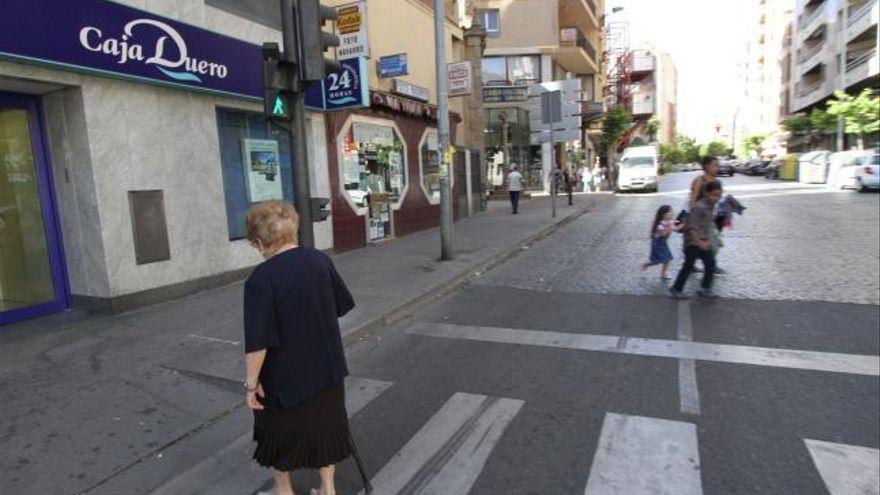 Ayudada por un bastón, una señora cruza la calle de Víctor Gallego. Imagen de archivo