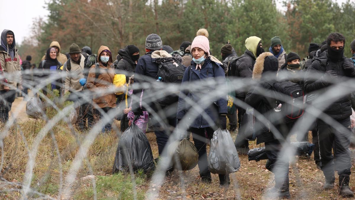 Refugiados y migrantes caminan junto a la frontera con polonia en la región bielorrusa de Grodno, este lunes.