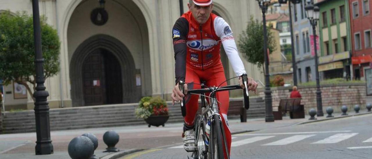 Juan Marcelino Huerdo, con su bicicleta, por las calles de Sama de Langreo.