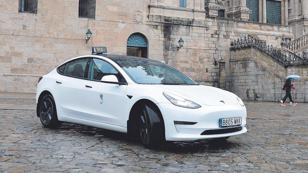 Borja Abeijón, ayer, al volante de su taxi Tesla cien por cien eléctrico en la compostelana plaza del Obradoiro