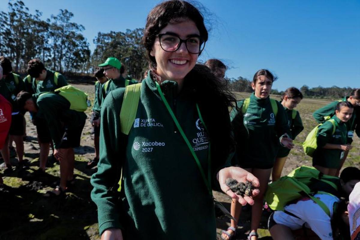 Una participante en la Ruta Quetzal muestra los bivalvos recogidos en O Esteiro.