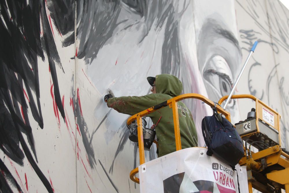 Lula Goce pinta un mural en la fachada de Bellas Artes de la UMU