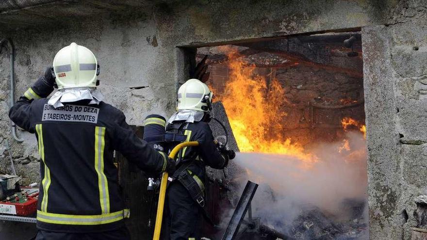 Bomberos de Deza-Tabeirós-Montes, apagando el fuego en la casa de Castro de Cabo en 2015.//Bernabé/J.L.