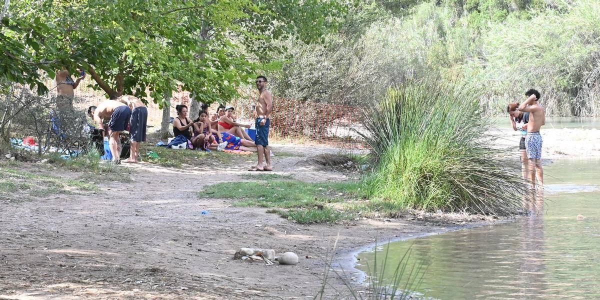Cientos de personas aprovechan la playa del Millars en el Termet para refrescarse y aliviar las altas temperaturas.