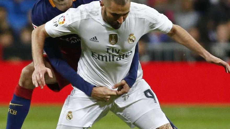 Busquets agarra a Benzema en el Madrid-Barcelona de la temporada pasada en el Bernabéu. // Reuters