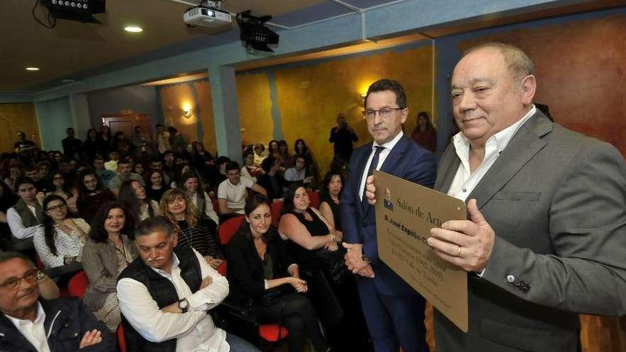 José Sendiño, junto al consejero Genaro Alonso, muestra la placa al público asistente al acto en el IES de Turón.