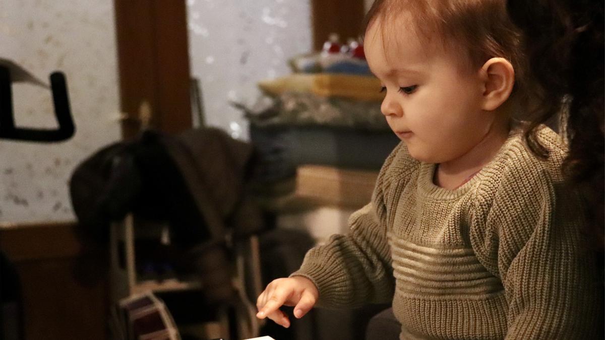 L'Alejandro, un nen amb una malaltia minoritària, toca una tecla del piano mentre fa musicoteràpia a casa