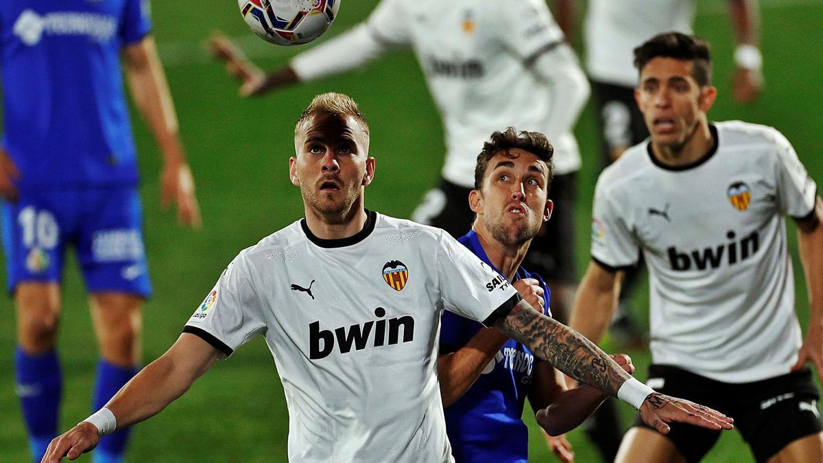 Uros Racic intenta controiar la pelota ante la pegajosa marca de Jaime Mata. | EFE/EMILIO NARANJO