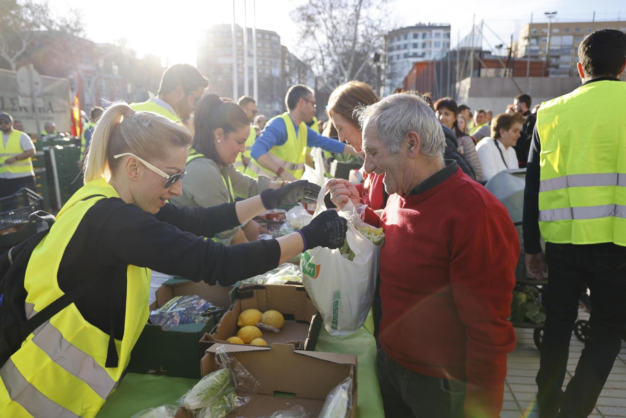 Las imágenes del plante de los agricultores frente a la Asamblea, donde han repartido frutas y hortalizas