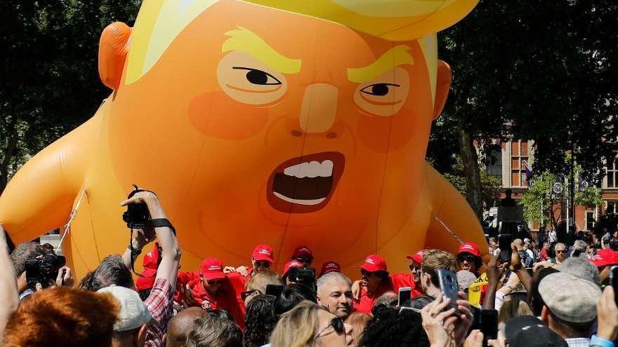 Manifestantes protestan con un globo gigante que parodia a Donald Trump. // AFP