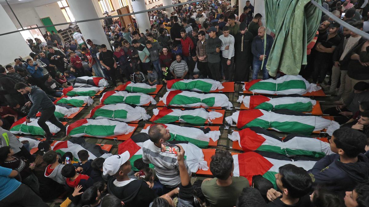 Palestinos llevan los cuerpos envueltos en banderas...