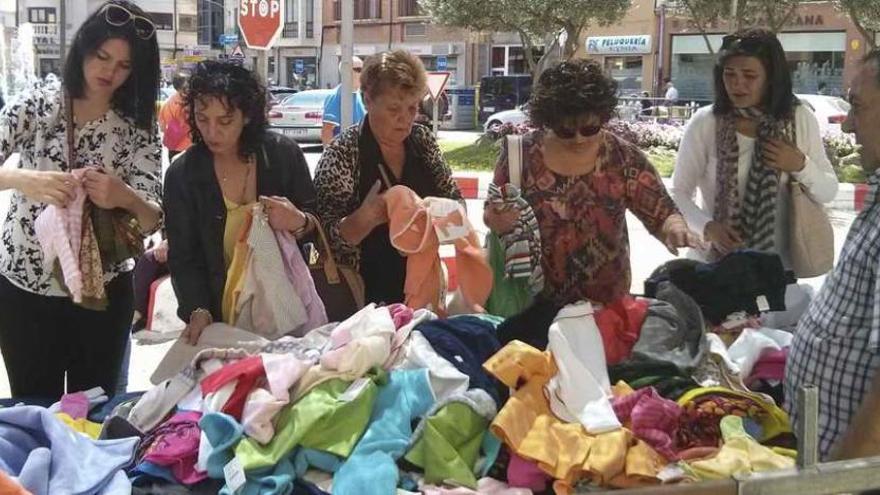 Varias mujeres observan las prendas en un puesto de venta.