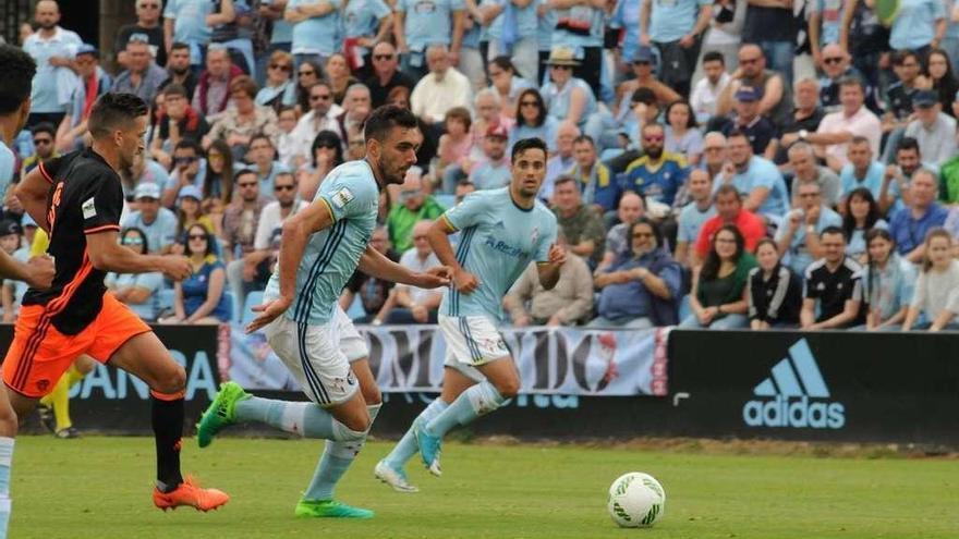 Borja Iglesias conduce la pelota perseguido por un jugador del Valencia Mestalla durante el choque disputado en Barreiro. // Eugenio Álvarez