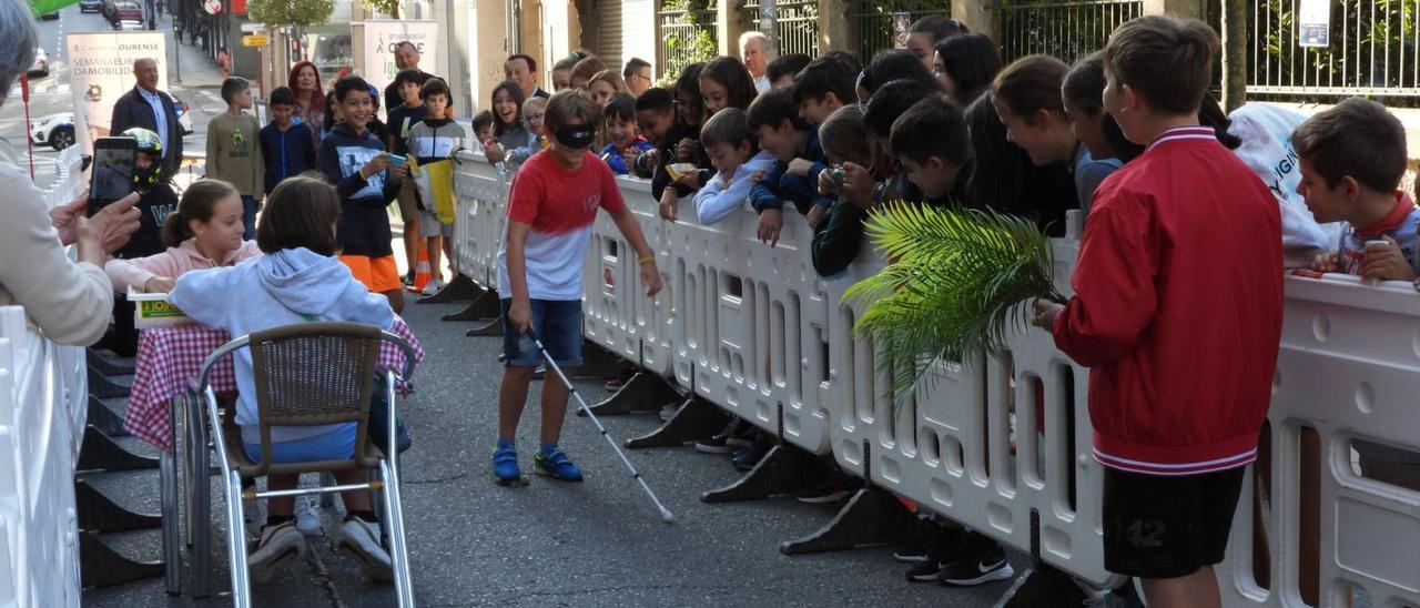 Uno de los escolares camina a ciegas por el circuito de obstáculos ayudándose de un bastón. |   // FERNANDO CASANOVA