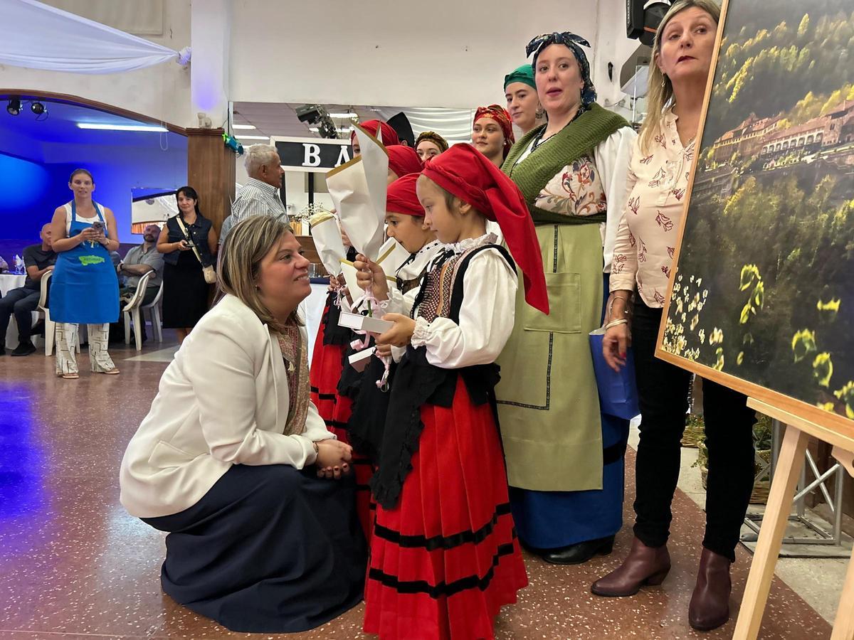 La vicepresidenta del Principado recibe un obsequio de una de las integrantes del grupo "Les madreñes".