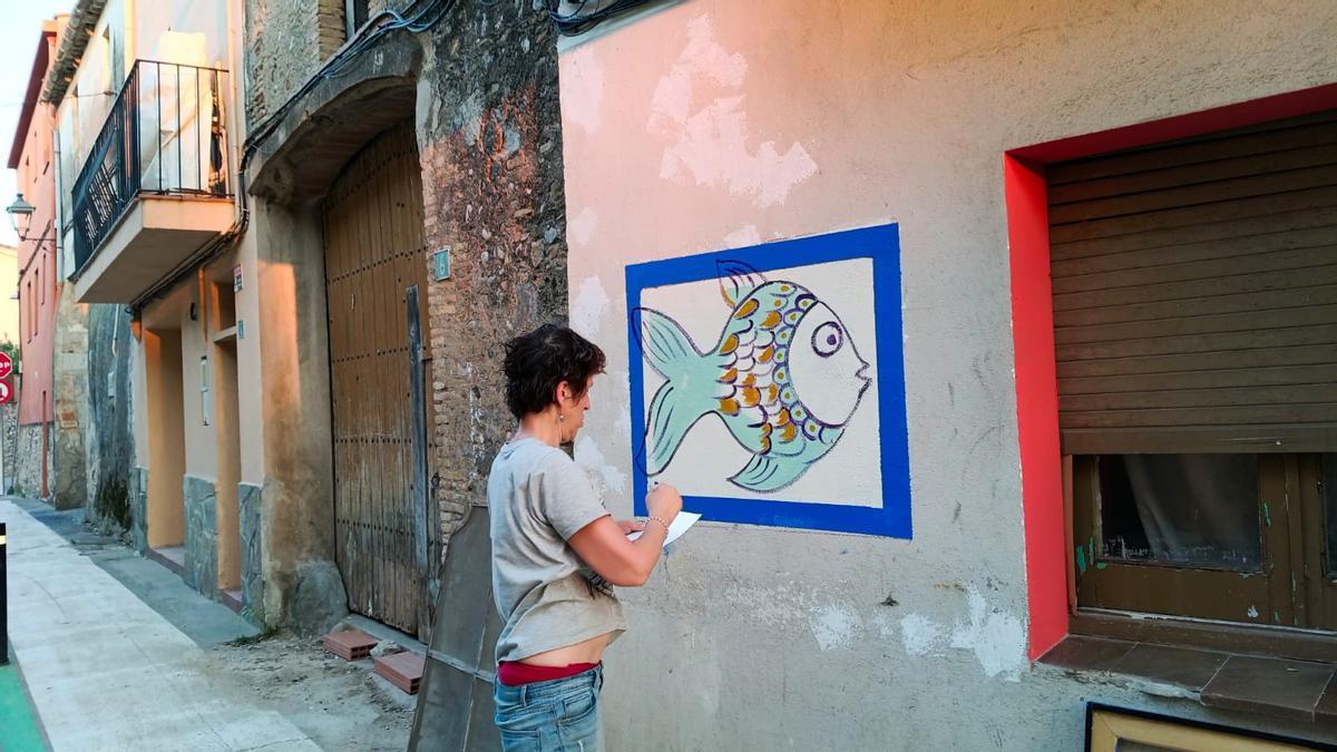L'artista Anna Novella fent els primers peixos del mural