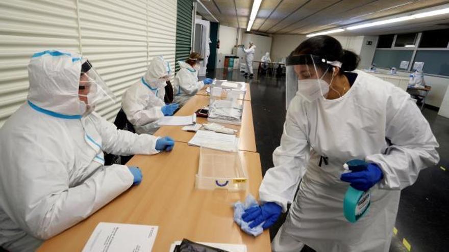 Gafas, pantalla y mono para evitar contagios durante la última hora de las votaciones