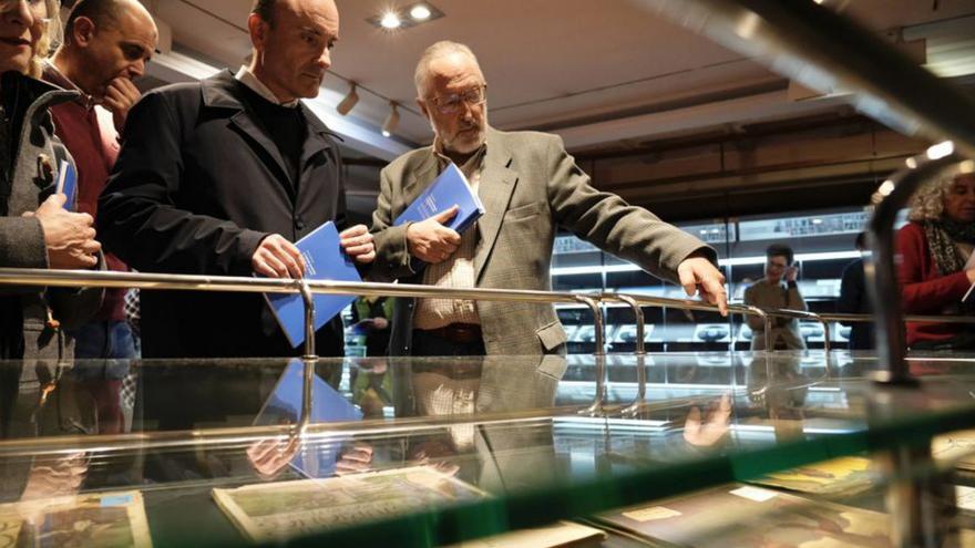 El director xeneral de Patrimoniu Cultural, Pablo León, atiende a les indicaciones sobre l'amuesa de discos que-y fai'l director de la Biblioteca d'Asturies, Juan Miguel Menéndez.