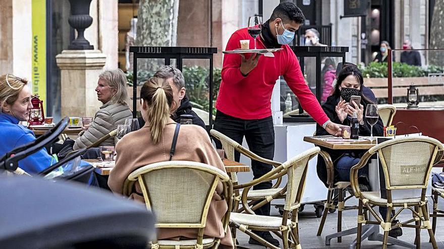 Un camarero sirviendo a una clienta en una terraza del Passeig des Born.