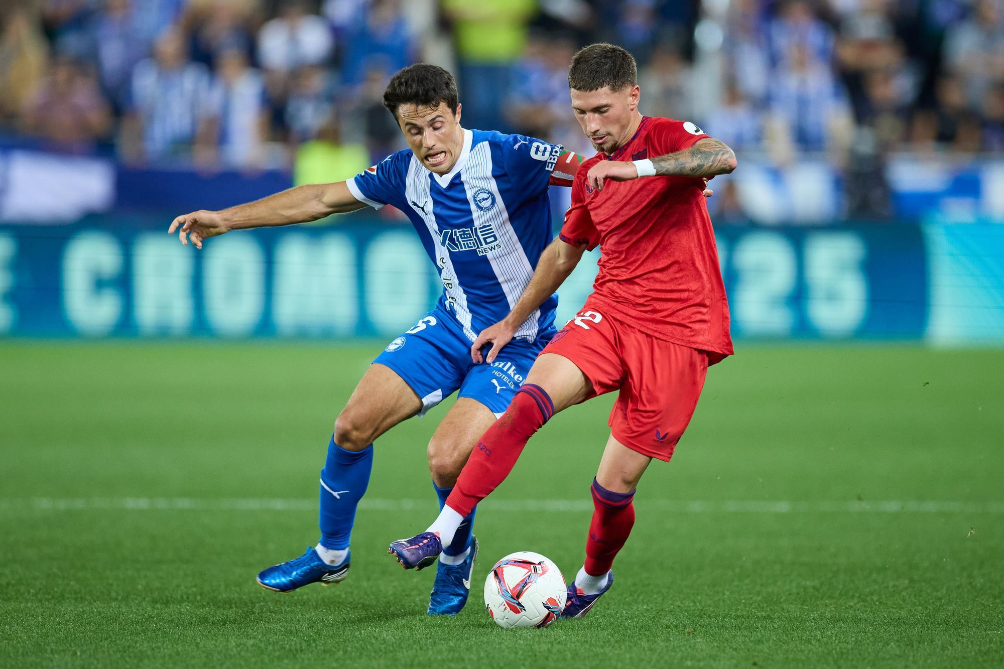 Ander Guevara of Deportivo Alaves competes for the ball with Jose Angel Carmona of Sevilla FC during the LaLiga EA Sports match between Deportivo Alaves and Sevilla FC at Mendizorrotza on September 20, 2024, in Vitoria, Spain. AFP7 20/09/2024 ONLY FOR USE IN SPAIN / Ricardo Larreina / AFP7 / Europa Press;2024;SOCCER;SPAIN;SPORT;ZSOCCER;ZSPORT;Deportivo Alaves v Sevilla FC - LaLiga EA Sports;