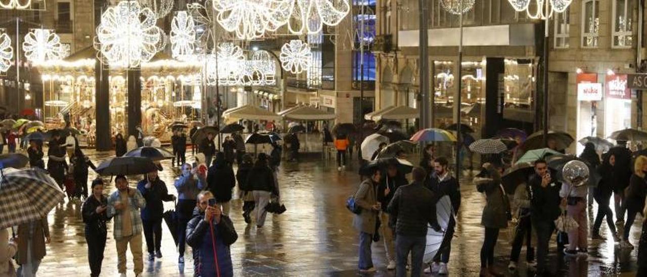 Varias personas fotografían el árbol gigante de Porta do Sol, uno de los puntos clave de la Navidad de Vigo.