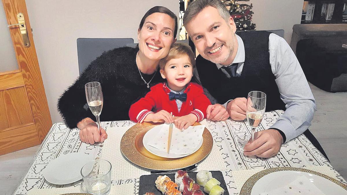 Alicia Rodríguez, José Heredia y el pequeño Hugo, con la mesa preparada para la cena.