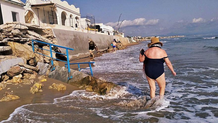 Los bañistas pasan por el tramo más deteriorado de les Deveses.