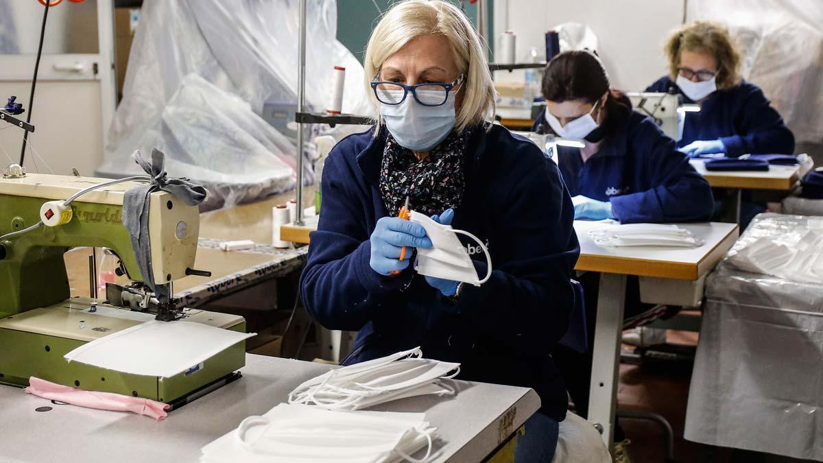 Italia llega al pico de contagios pero la vuelta a la normalidad será lenta. En la foto, una trabajadora de un taller de mascarillas cerca de Roma.