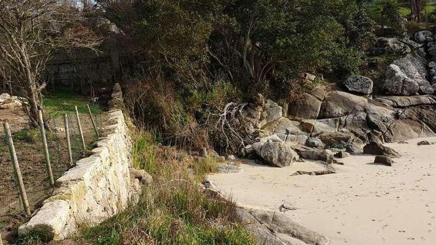El muro de piedra en la playa de Sartaséns que provoca malestar vecinal. // Fdv