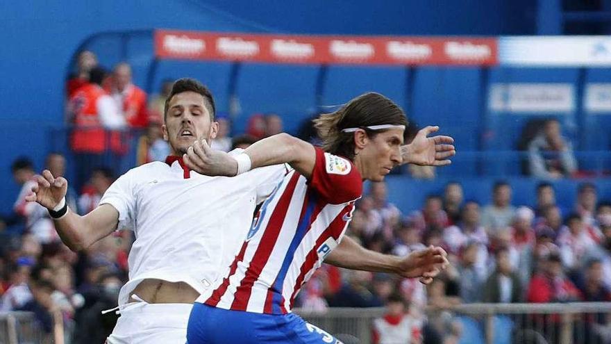Jovetic, del Sevilla, presiona al colchonero Filipe Luis en el partido de ayer. // Zipi
