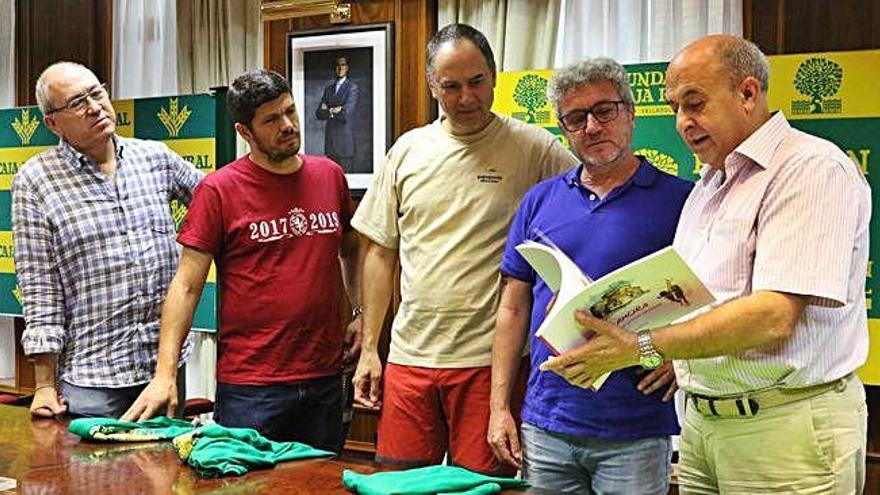 Desde la izquierda: Alberto, Manu, Erundino y Valentín, reciben un libro de Zamora de manos de Feliciano Ferreo en Caja Rural.
