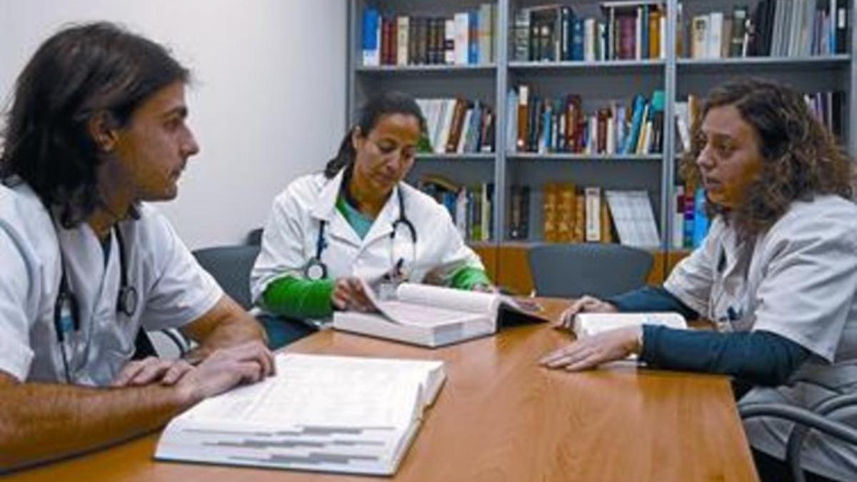 Tres médicos, en la biblioteca del CAP de la Marina de Barcelona, ayer.