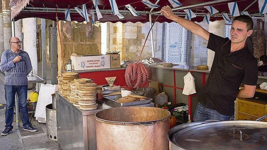 Un camarero cuece un pulpo en una caseta instalada en la Plaza Mayor.