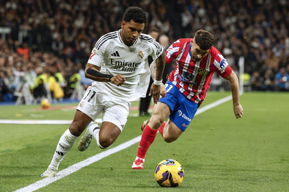 FOTODELDÍA  MADRID, 08/02/2025.- El delantero brasileño del Real Madrid, Rodrygo (i), se lleva el balón ante el defensa del Atlético de Madrid, Javi Galán, durante el encuentro correspondiente a la jornada 23 de Laliga EA Sports que disputan hoy sábado Real Madrid y Atlético de Madrid en el estadio Santiago Bernabéu, en Madrid. EFE / Chema Moya.