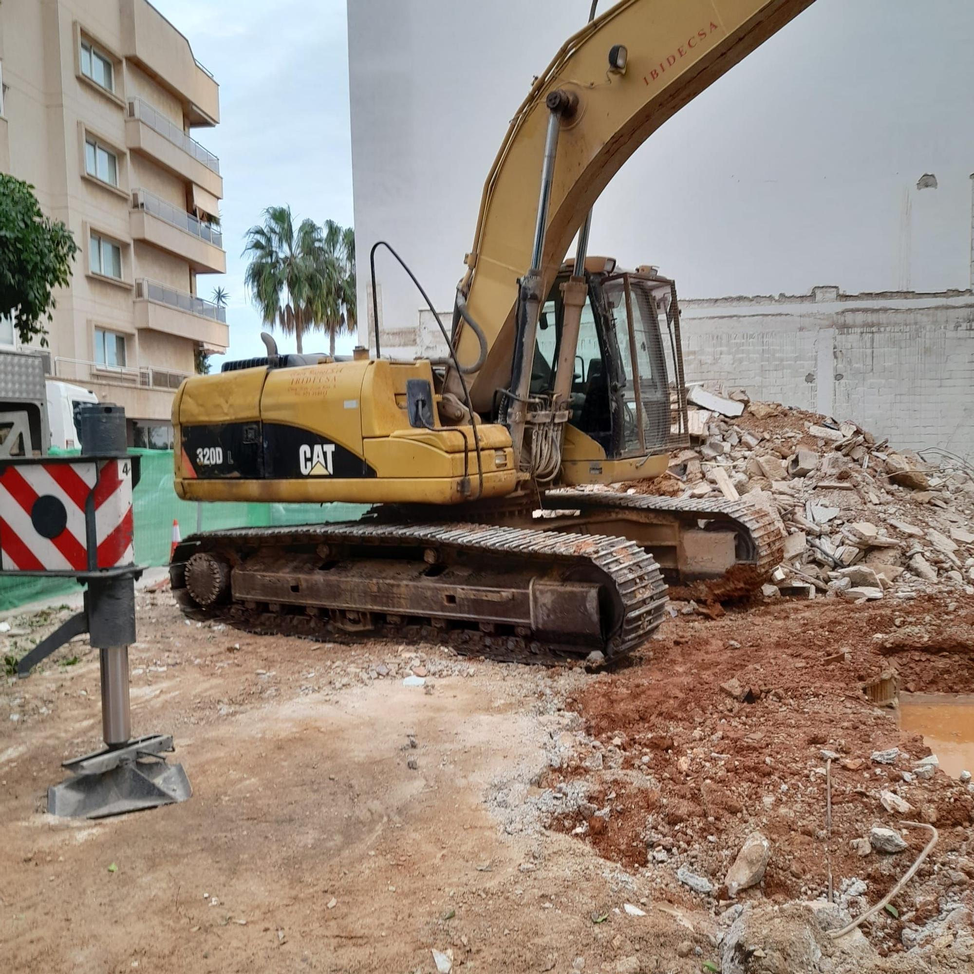 Excavadora hundida en la tierra de un solar en obras en Ibiza