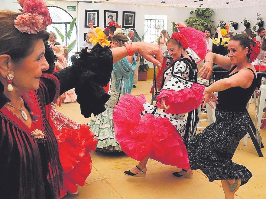 Un grupo de mujeres baila sevillanas en una caseta.